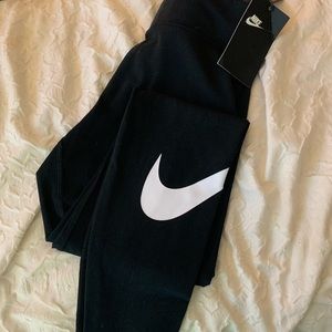 Nike leggings with a white swoosh on the leg.  Size medium and with tags.